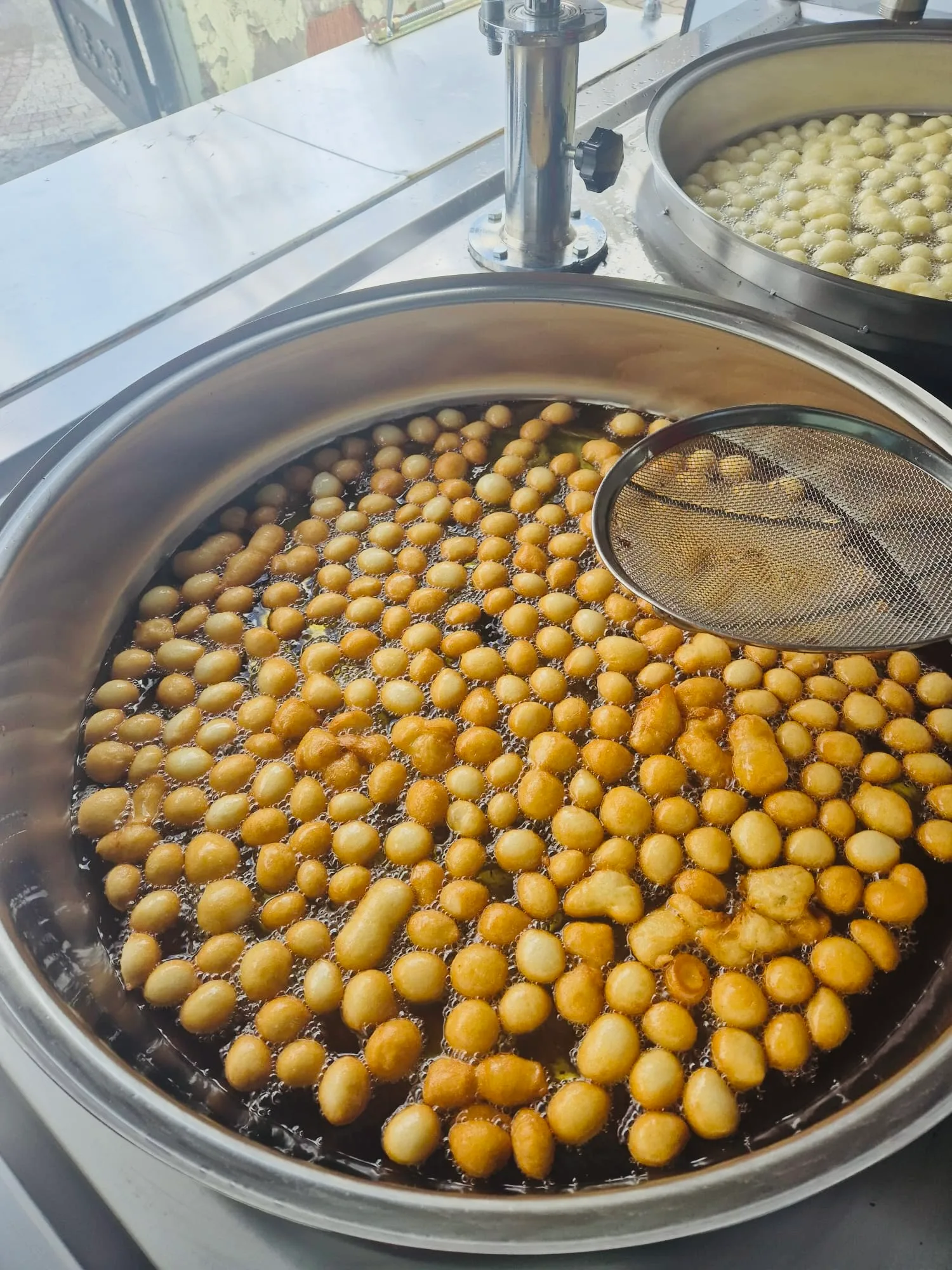 Kızgın yağda dökülen lokmalar, kevgirle karıştırılıyor